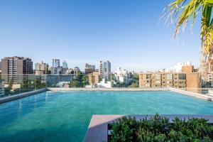 a large swimming pool with a city skyline in the background at Skyline Parque Moinhos by LikeHome in Floresta