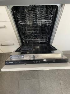 a dishwasher with its door open in a kitchen at Moderne Ferienwohnung mit Balkon und Klima in Neufraunhofen +5 photos