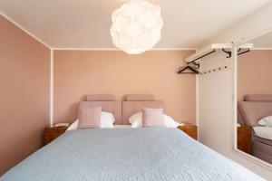 a bedroom with a large bed and a chandelier at Siestalodge 1 in Pelzerhaken