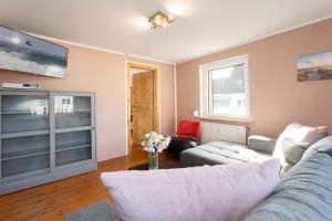 a living room with a couch and a tv at Siestalodge 1 in Pelzerhaken