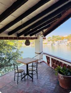a table and chairs on a patio with a view of the water at La Calita de Teques in Tequesquitengo