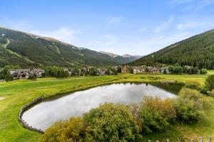 a golf course in the mountains with a pond at Greens at Copper #314 in Copper Mountain