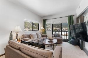 a living room with a couch and a tv at Greens at Copper #314 in Copper Mountain
