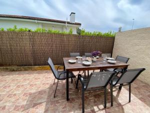 a wooden table and chairs on a patio at Apartamento La Bruma 30807 in Somo