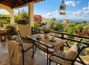 a patio with a table and chairs on a balcony at Marsia House in Vathí