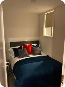 a bedroom with a bed with red and blue pillows at Dorrians Corner Killybegs, Donegal in Killybegs