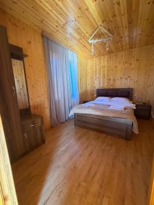 a bedroom with a bed in a wooden cabin at Mtis guli in Bangveti