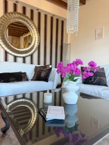a living room with a glass table with flowers on it at Marsia House in Vathí