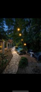 a stone walkway with benches and trees in a yard at B&B The Parklane Retreat in Schoten