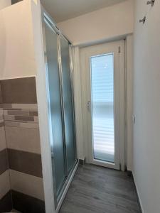 a bathroom with a glass door and a shower at Urban House in Nuoro