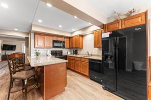 a kitchen with a black refrigerator and wooden cabinets at Rockridge #51 in Breckenridge