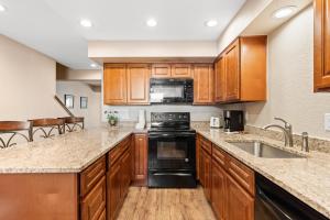 a kitchen with wooden cabinets and black appliances at Rockridge #51 in Breckenridge