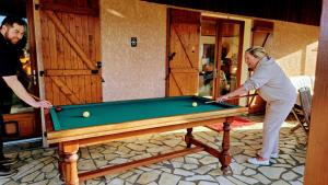 a man and a woman playing a game of pool at Chambres Du Petit Bonheur in Biscarrosse