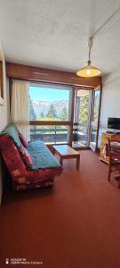 a bedroom with a bed and a balcony with mountains at L'Ancien Temps in Ustou