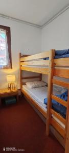 two bunk beds in a room with a ladder at L'Ancien Temps in Ustou