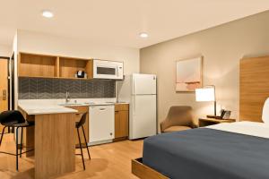 a hotel room with a bed and a kitchen at LivAway Suites Phoenix-Surprise in Surprise