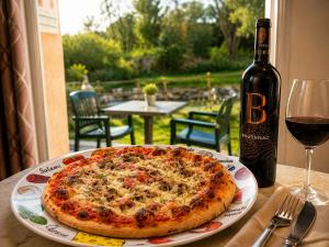 a pizza sitting on a table next to a bottle of wine at Oasis Des Corbières in Boutenac
