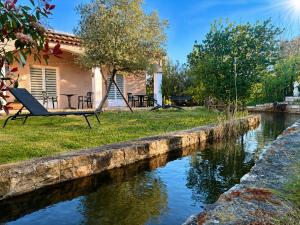 a house with a hammock next to a river at Oasis Des Corbières in Boutenac