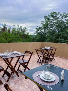 two tables and chairs sitting on a patio at Vila Fox Estadia in Lençóis