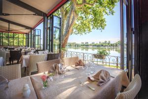 a dining room with a view of a river at Gîtes les rives de Saône in Saint-Didier-sur-Chalaronne