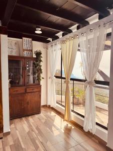 a room with a large window with white curtains at Cabañas La PetiteChef in El Limar