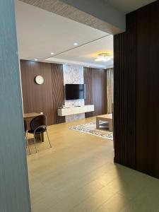 a living room with a table and a television at Newly built Modern 2 BR apartment in Ulaanbaatar