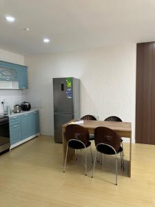 a kitchen with a table and chairs and a refrigerator at Newly built Modern 2 BR apartment in Ulaanbaatar