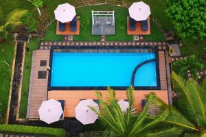 an overhead view of a swimming pool with umbrellas at Mamaras Guest House in Nusa Penida