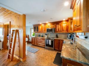 a kitchen with wooden cabinets and a ladder at Lakeside Haven, Tranquil Waters in Holland