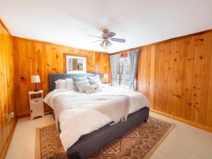 a bedroom with a large bed with wooden walls at Lakeside Haven, Tranquil Waters in Holland
