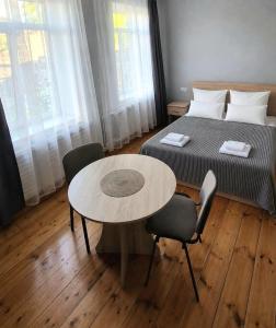 a bedroom with a bed and a table and chairs at Guest House David's B&B in Gyumri