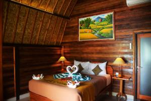a bedroom with two beds in a room with wooden walls at Mamaras Guest House in Nusa Penida