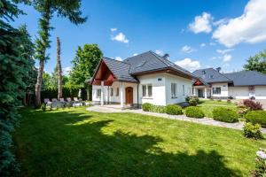 a white house with a green yard at Willa u Basi 2 in Miłków