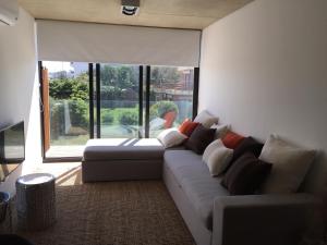sala de estar con sofá y ventana grande en Apartamento Rambla 24, en Punta del Este