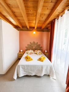 a bedroom with a bed with yellow pillows on it at Chambres d’hôtes A Casa Di Marigaby in Barbaggio