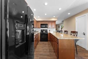 a kitchen with a black refrigerator and wooden cabinets at Rockridge #41 in Breckenridge