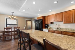 a kitchen with wooden cabinets and a kitchen island with chairs at Rockridge #41 in Breckenridge +26 photos