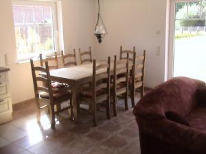 ein Esszimmer mit Tisch, Stühlen und Sofa in der Unterkunft Rood Huus in Dabitz
