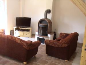 ein Wohnzimmer mit zwei Sofas und einem Holzofen in der Unterkunft Rood Huus in Dabitz