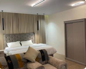 a bedroom with a large bed and a couch at نزل بسمة الأبداع in Abha