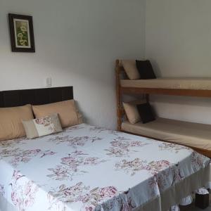 a bedroom with a bed and two bunk beds at Recanto Mosaico in São Sebastião +22 photos
