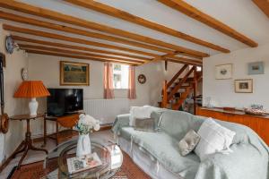 a living room with a couch and a tv at Cheesemans Cottage in Grimstone