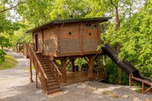 a tree house with a slide and a bench at "Squirrels Gone Wild" Luxury Treehouse Adventure Near Dollywood & Pigeon Forge in Sevierville