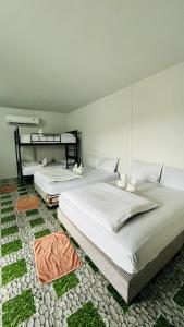 two beds sitting next to each other in a bedroom at Nadpob Mansion in Suratthani