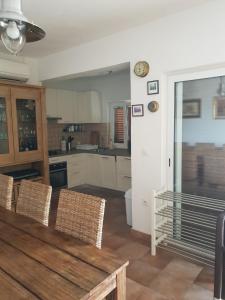 a kitchen with a table and chairs and a clock on the wall at Vicko villa in Seget Vranjica