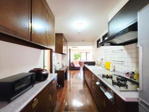 a kitchen with wooden cabinets and a counter top at 禮 -Rei House- in Muromimachi