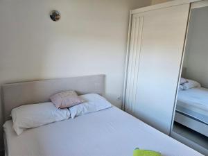 a bedroom with a white bed and a mirror at Apartman Sunce in Bosanska Gradiška