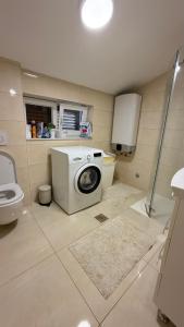 a bathroom with a washing machine and a toilet at Vicko villa in Seget Vranjica