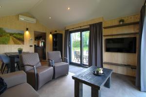 a living room with a couch and a table at Nieuw!! Chalet De Luxe 4 persoons met airco in Oorsbeek