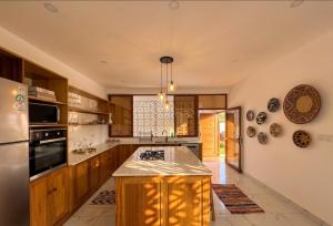 a kitchen with wooden cabinets and a large island at Casa Samara in Diani Beach